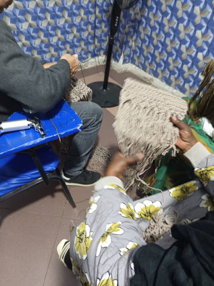 مشاركون يعملون على نسج خيوط المكرمية